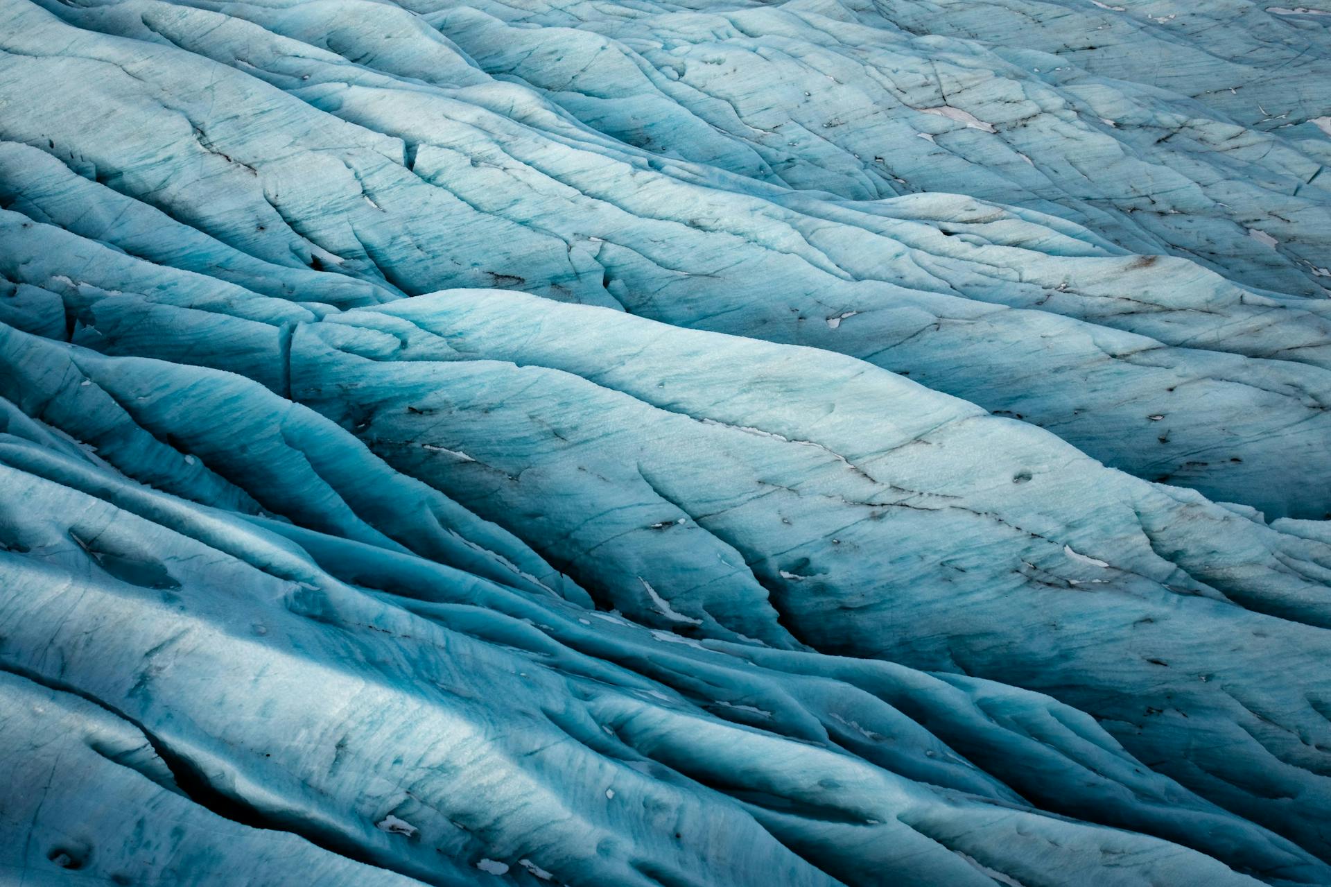 Impressive textures of blue glacier ice with detailed surface patterns indicating natural formations.