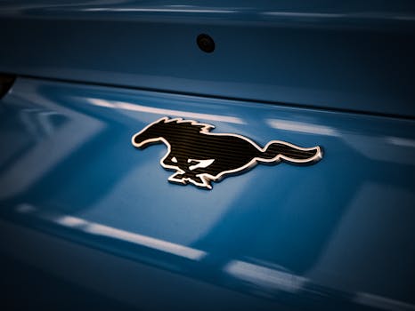 Detailed close-up of the iconic Mustang horse logo on a blue car surface.
