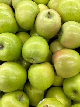 A vibrant collection of fresh green apples captured in a close-up view.