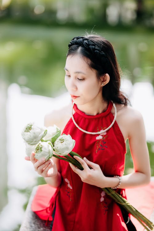 A woman in red holding white flowers