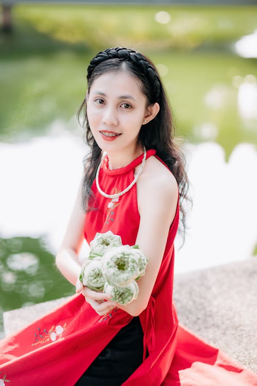 A woman in red holding a bouquet of flowers