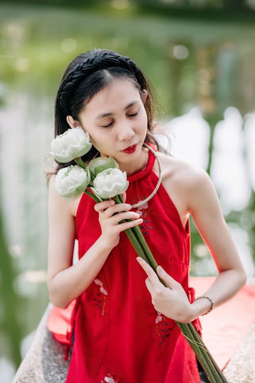 A woman in red holding a bunch of white flowers