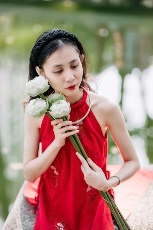 A woman in red holding white flowers