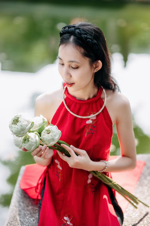 A woman in a red dress holding flowers