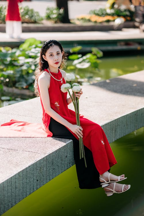 Woman in Red, Traditional Clothing Sitting with Flowers