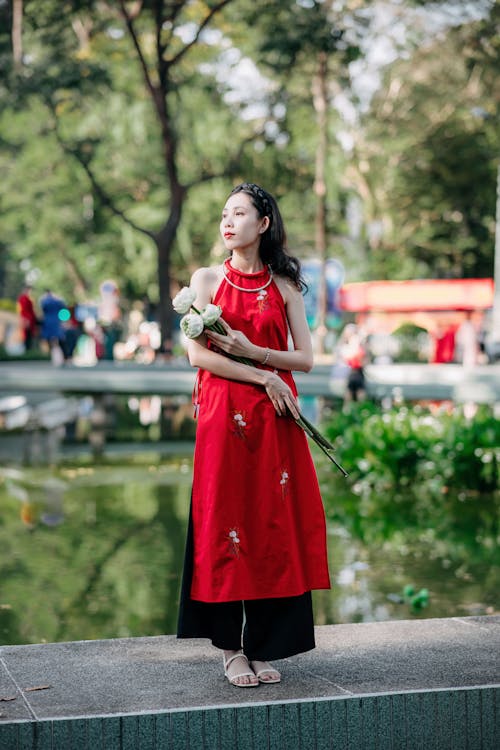 Woman in Traditional Dress and with Flowers at Park