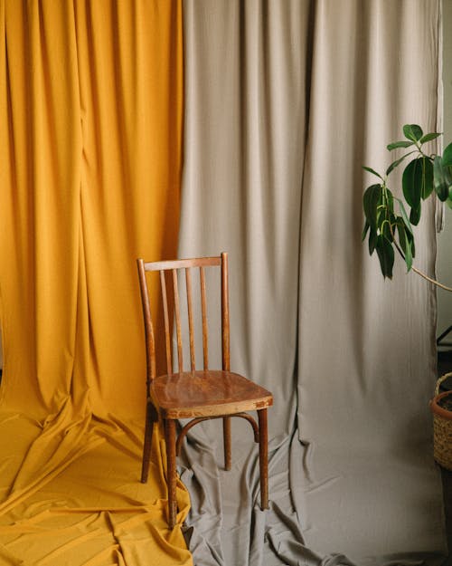 A chair sits in front of a curtain with yellow and gray
