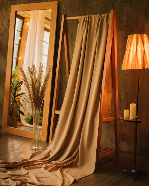 A tan curtain is hanging on a wooden frame