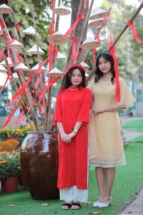 Two asian women in traditional dress standing next to each other