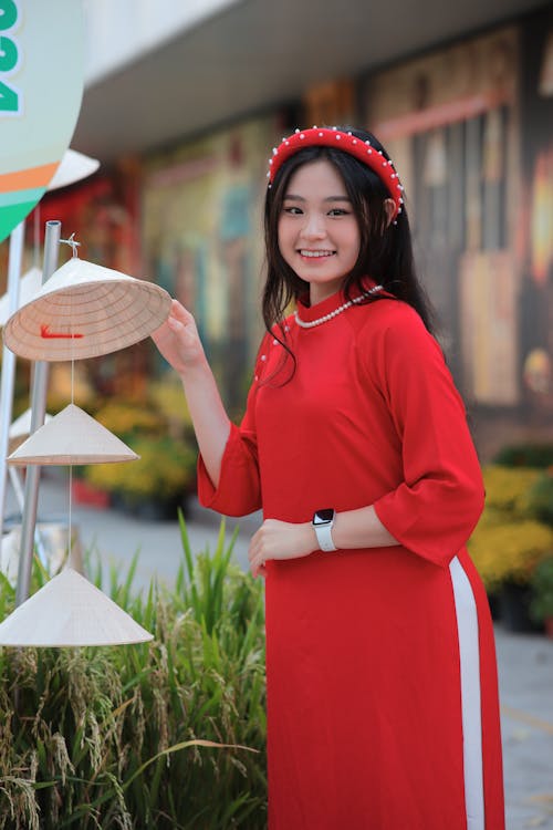 Smiling Woman in Traditional Clothing Standing with Conical Hats