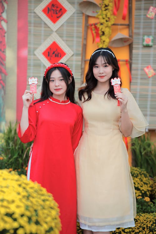 Two asian women in traditional dress holding up chinese lanterns