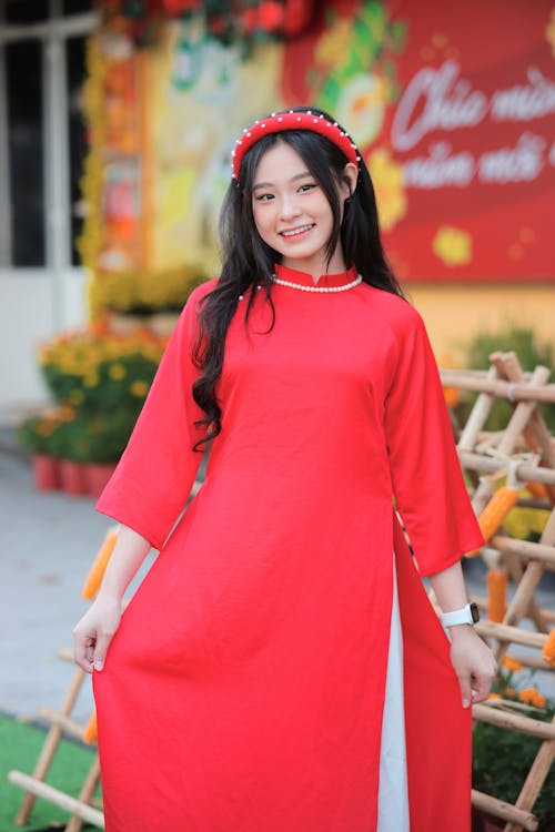 A woman in a red dress posing for the camera