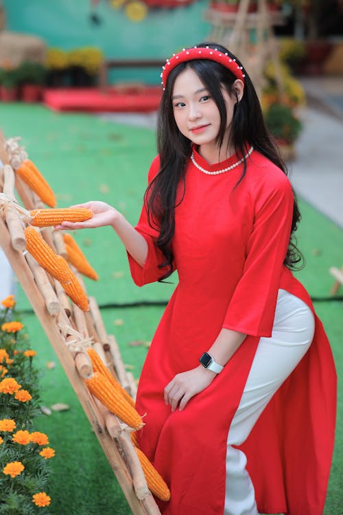 A woman in a red dress holding carrots