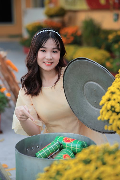 A woman in yellow dress holding a can of beer