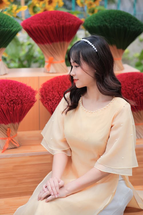 A woman in a yellow dress sitting on a bench