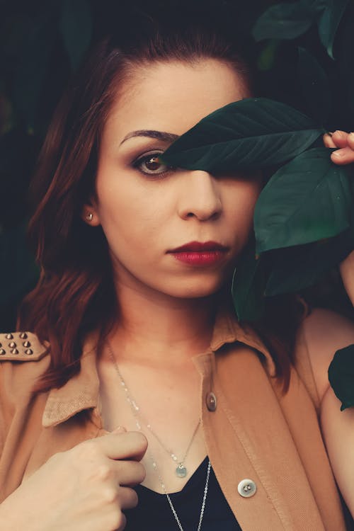 Woman Covering Eye With Leaf