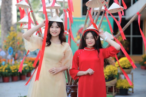 Two asian women in traditional dress pose for a photo