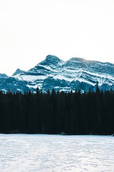 Stunning snowy mountain view over a frozen lake in Banff National Park, Alberta.
