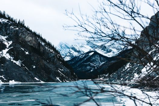 Stunning winter scenery of frozen mountains and lake in Kananaskis, Alberta, Canada.