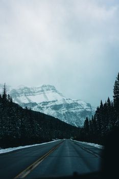 Snow-covered mountains and road in Banff National Park, perfect for winter adventures.
