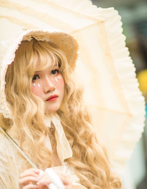 Free Beautiful portrait of a young woman in cosplay with an umbrella and face paint. Stock Photo