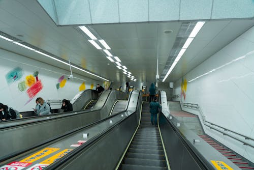 A long escalator with people walking up and down