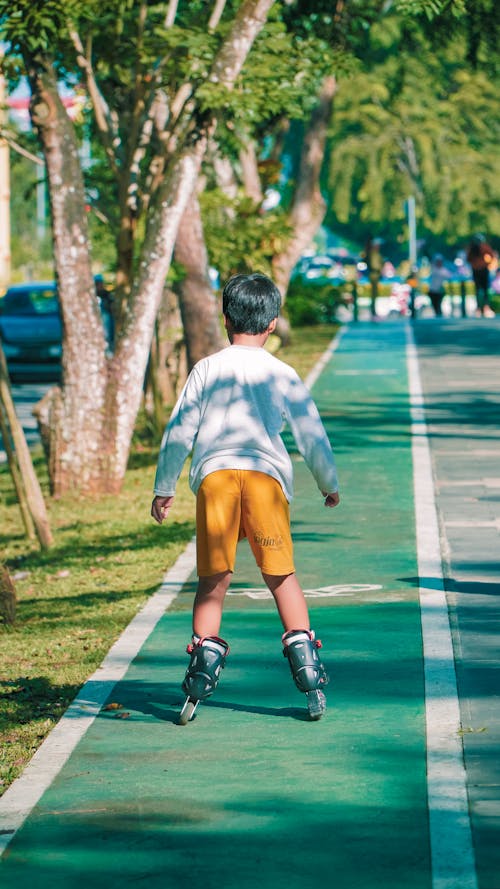 A child is riding a skateboard down a street