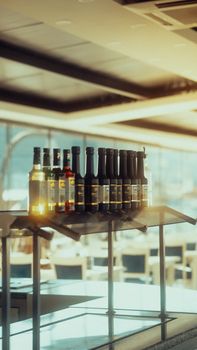 A modern bar setting with a selection of various beverage bottles in warm lighting.