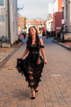 一位身着黑色连衣裙的时装模特，漫步在佐治亚州玛丽埃塔古色古香的街道上