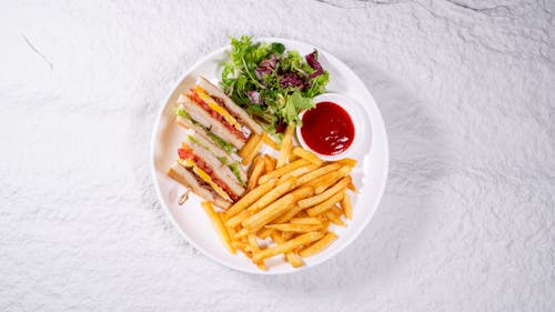 A plate with a sandwich and french fries