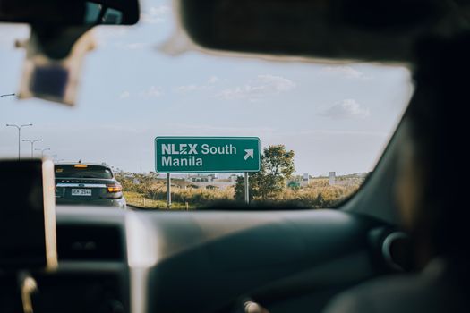 View from a car driving towards Manila on NLEX South, showcasing the road sign.