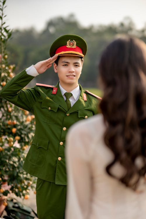 A soldier saluting a woman in uniform