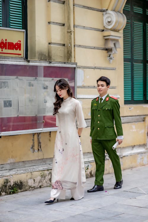 Soldier and a Young Woman Walking along the Sidewalk