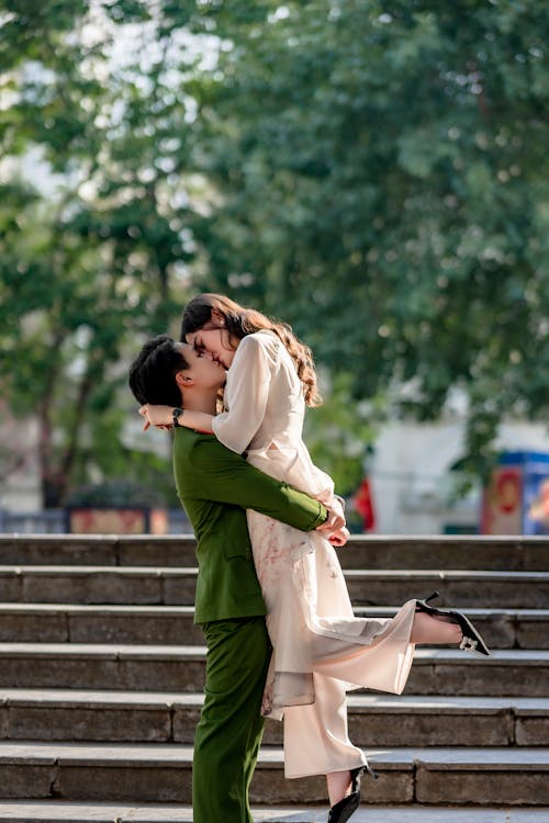 A couple kissing on the steps of a building