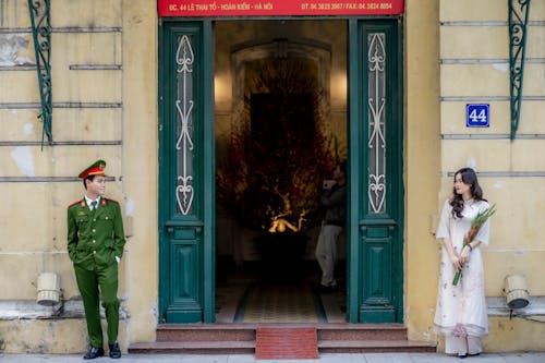 A man and woman standing in front of a green door