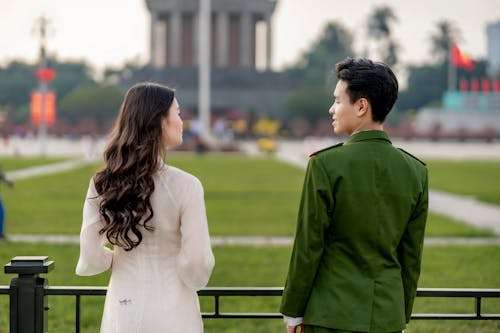 Soldier and a Young Woman Standing Together in Front of the Ho Chi Minhs Mausoleum