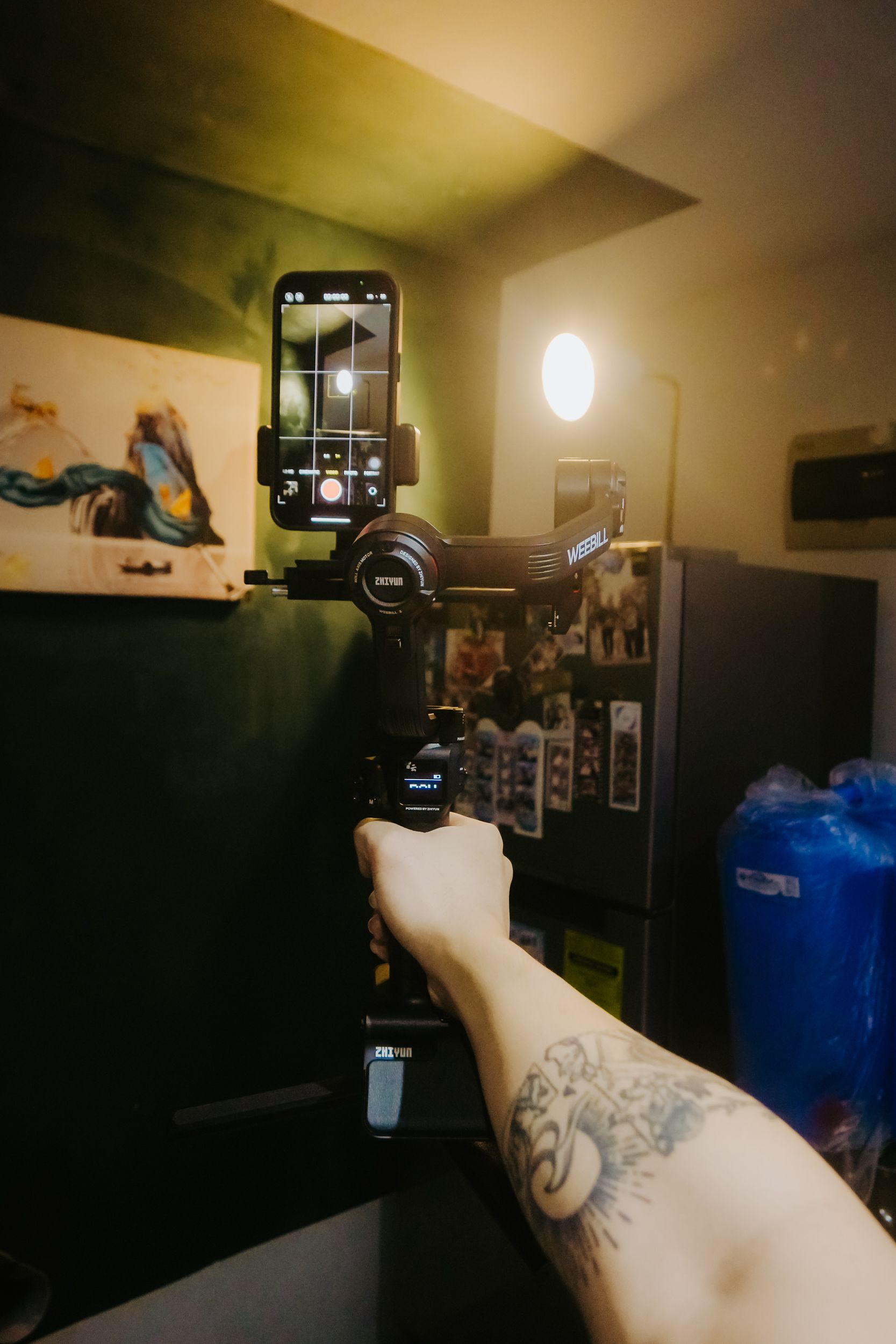 Braço segurando smartphone em gimbal, bastidor de filmagem