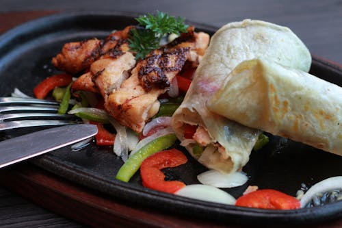 무료 검은 타원형 지글 지글 접시에 고기와 야채 스톡 사진