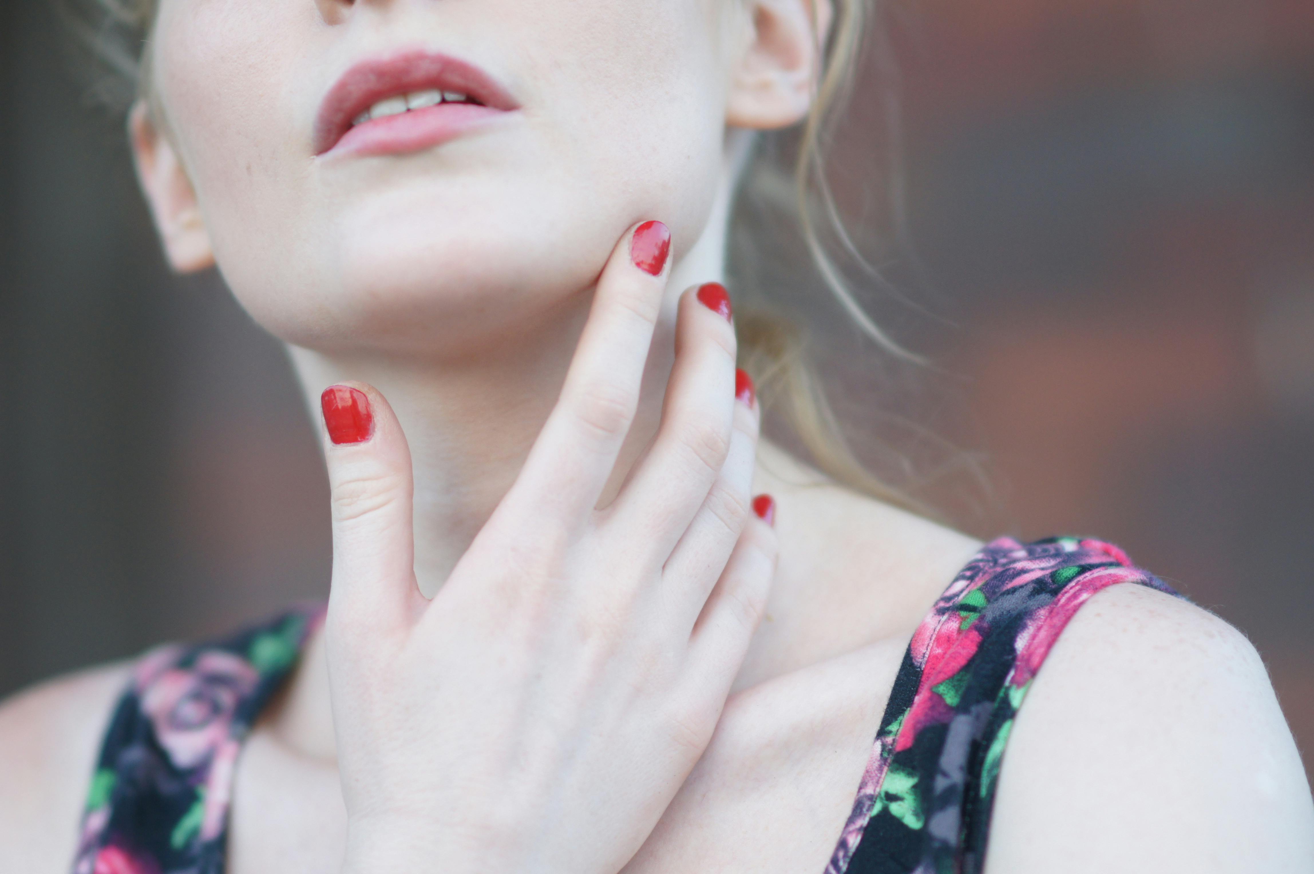 Close-up portrait of a woman with red nails and blonde hair, exuding elegance and fashion style.