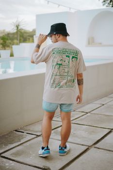 Man in casual wear enjoying a summer day by a poolside terrace. Fresh and relaxed vibe.