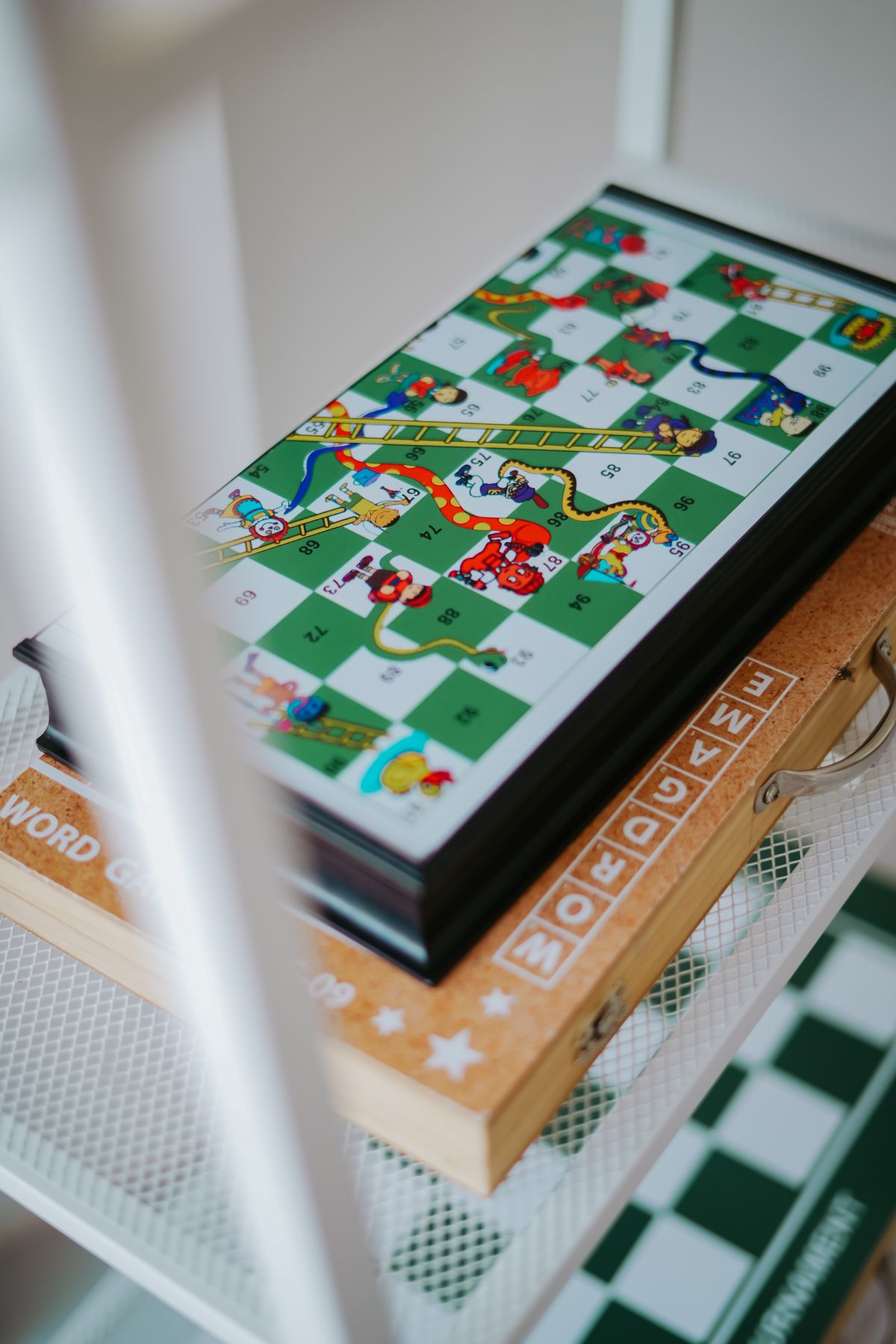 Board game stored neatly on a white shelf in a small apartment