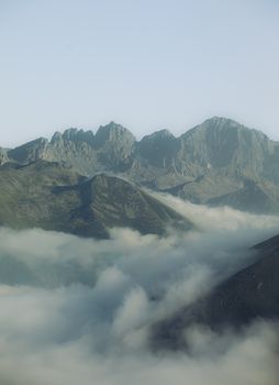 A breathtaking view of mountain peaks rising above a sea of clouds, captured from above.