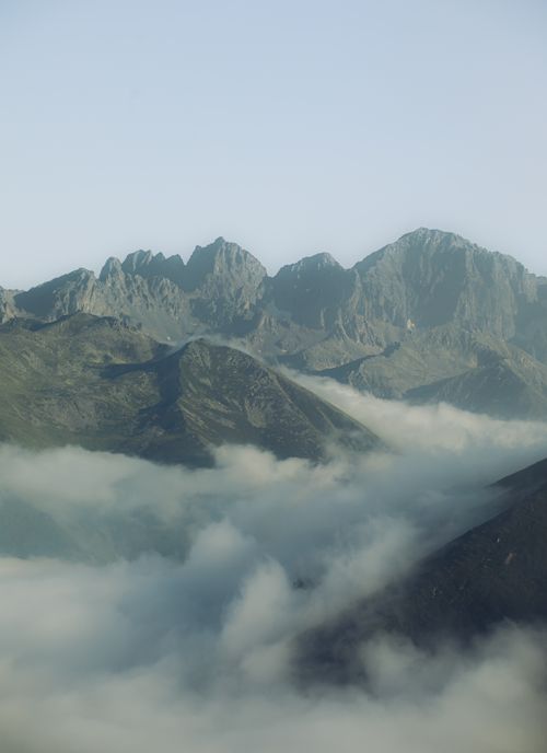 Free A breathtaking view of mountain peaks rising above a sea of clouds, captured from above. Stock Photo