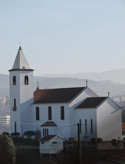 A white church with a steeple on top of a hill
