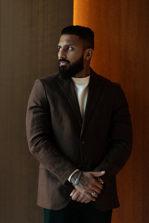A man with a beard and a brown jacket