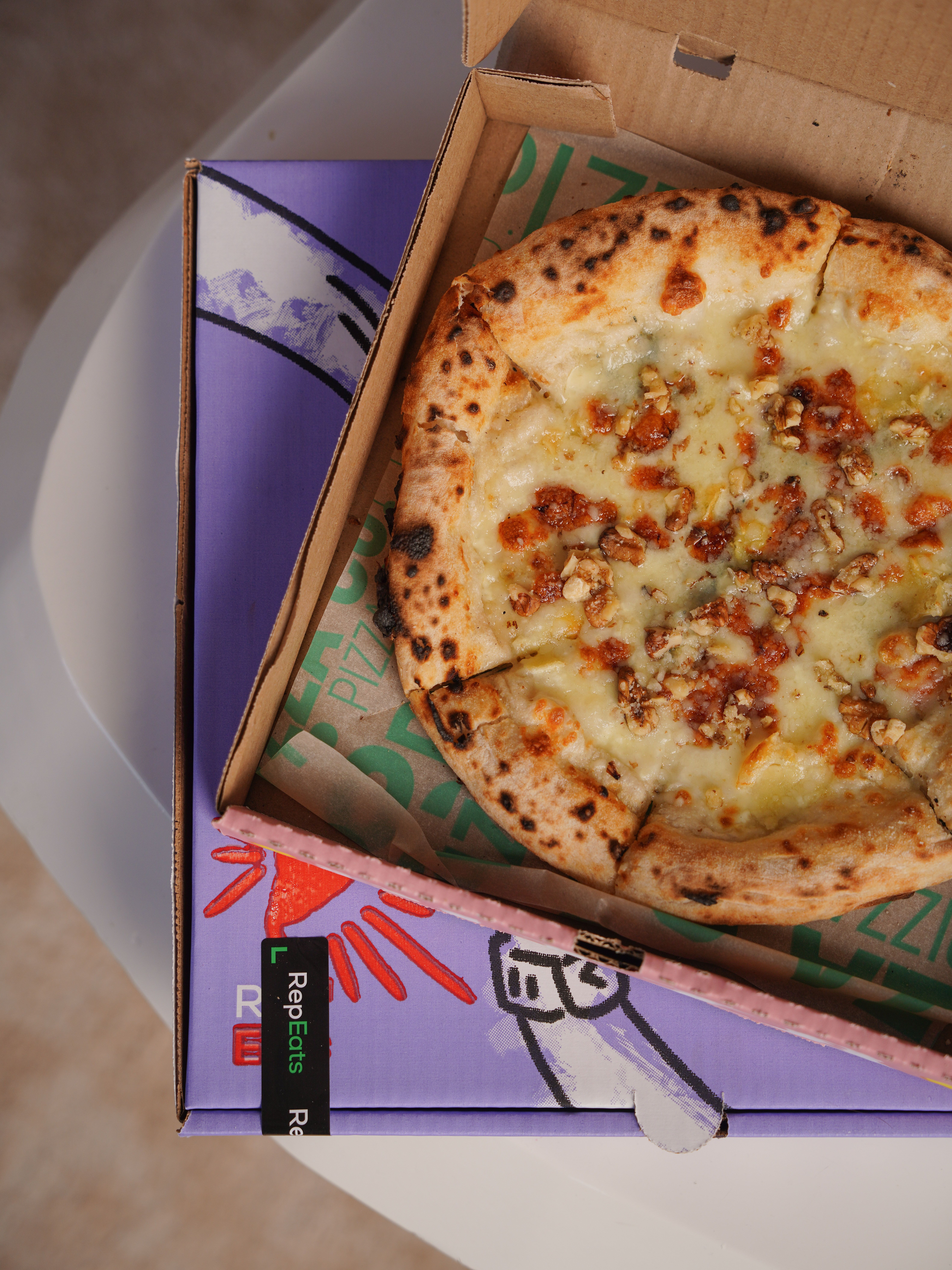 Fresh cheesy pizza in an open box viewed from above, perfect for food lovers.