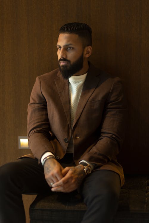 Man Sitting in Brown Suit