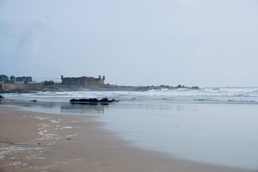 Serene coastal scene in Matosinhos, Portugal featuring a historic fort on a cloudy day.