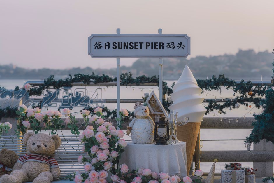 A beautifully decorated Sunset Pier with teddy bears, roses, and a giant ice cream cone, capturing a serene vacation vibe.
