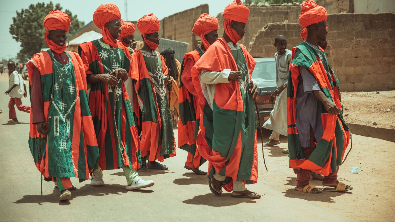 Men walking in traditional clothing on street in village, Niger